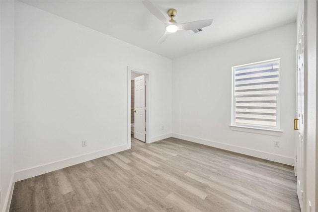 spare room featuring visible vents, ceiling fan, baseboards, and light wood-style floors