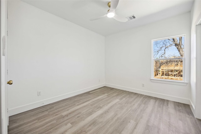 spare room with light wood finished floors, visible vents, ceiling fan, and baseboards