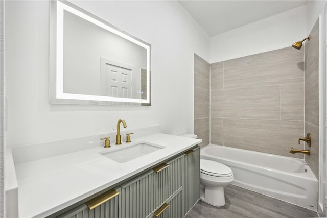 bathroom with tub / shower combination, toilet, vanity, and wood finished floors