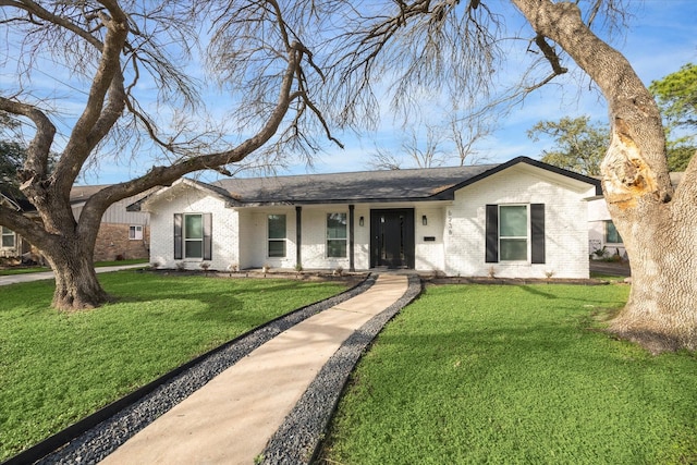 ranch-style house featuring a front yard and brick siding