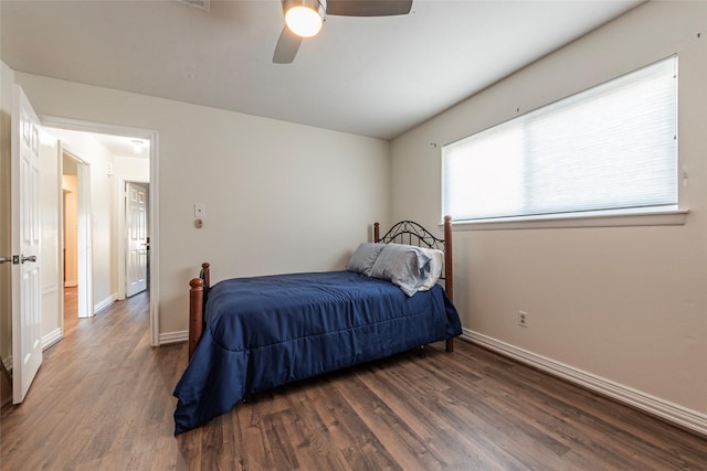 bedroom with ceiling fan, dark wood-type flooring, and baseboards