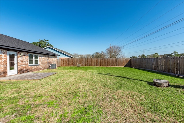 view of yard featuring central AC unit and a fenced backyard