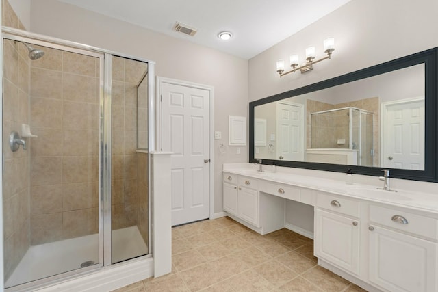 full bath with double vanity, a stall shower, a sink, and visible vents