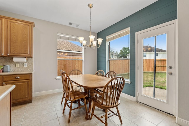 dining space with a chandelier, visible vents, and baseboards