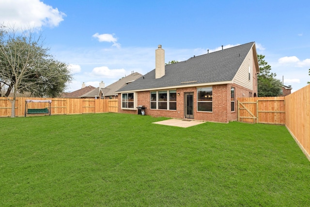 rear view of house with a fenced backyard, a gate, and a patio