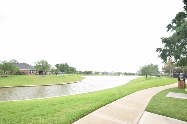 view of home's community with a water view and a yard