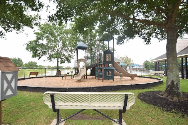 community play area featuring a lawn and fence