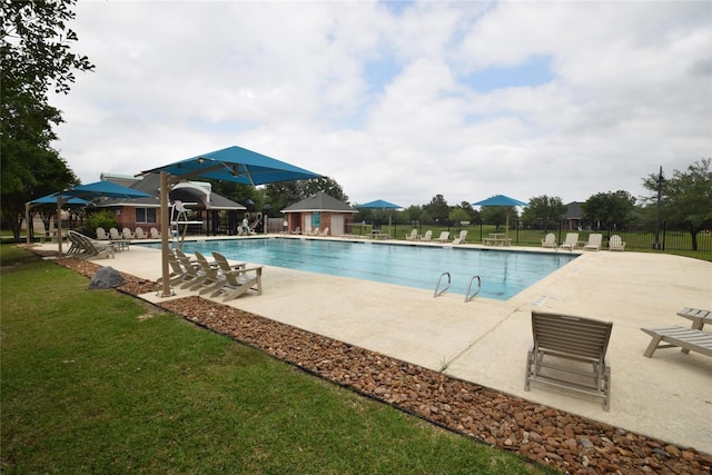 community pool featuring a patio, a yard, and fence