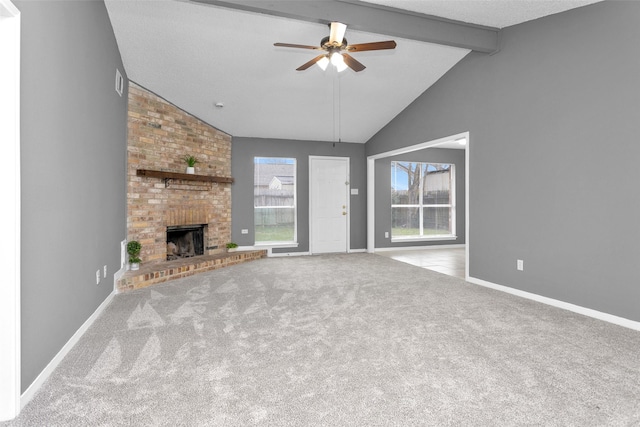 unfurnished living room with a brick fireplace, light colored carpet, beamed ceiling, and baseboards