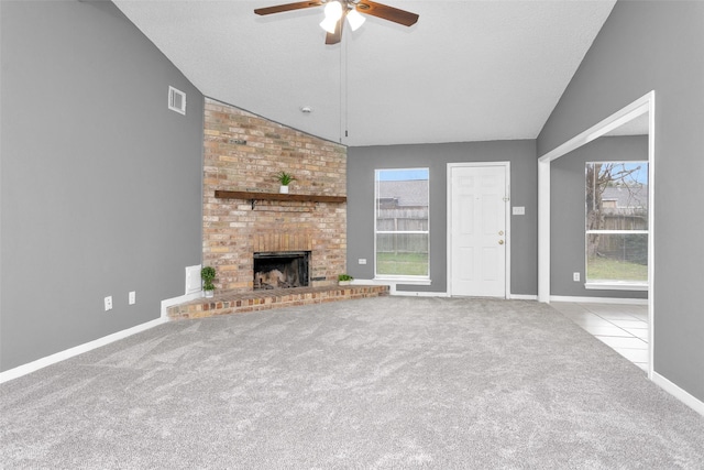 unfurnished living room featuring a wealth of natural light, vaulted ceiling, light carpet, and a fireplace