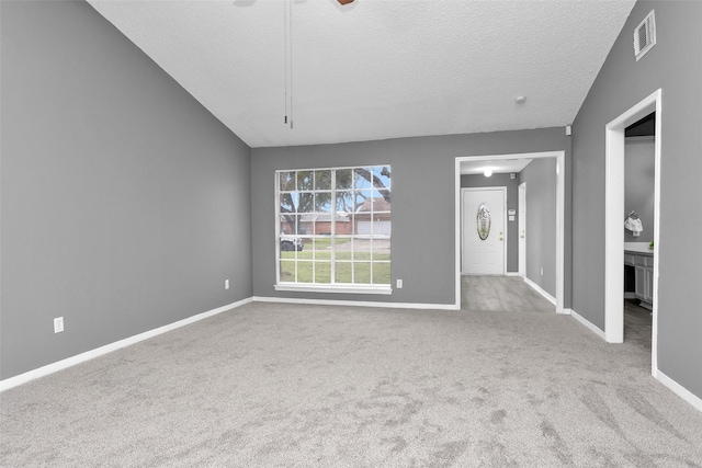 unfurnished room with baseboards, visible vents, a textured ceiling, and light colored carpet