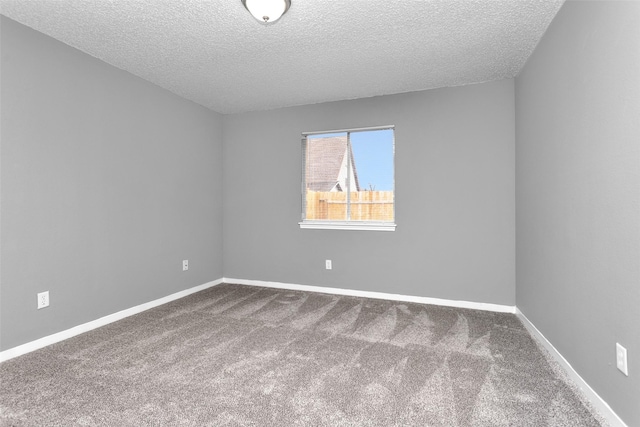 unfurnished room with carpet floors, a textured ceiling, and baseboards