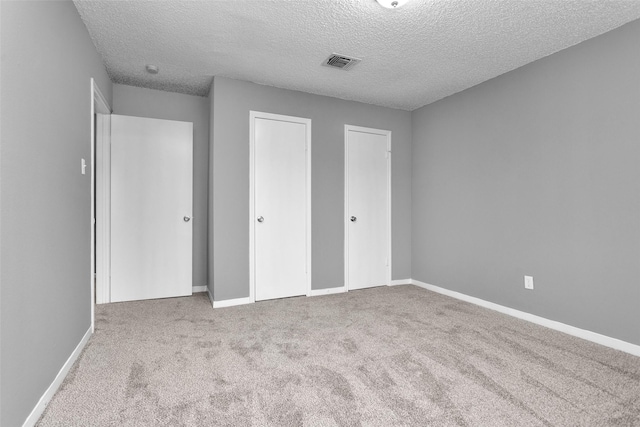 11330 Sunfish Ln, Houston, TX 77067 - unfurnished bedroom with carpet flooring, two closets, a textured ceiling, and baseboards