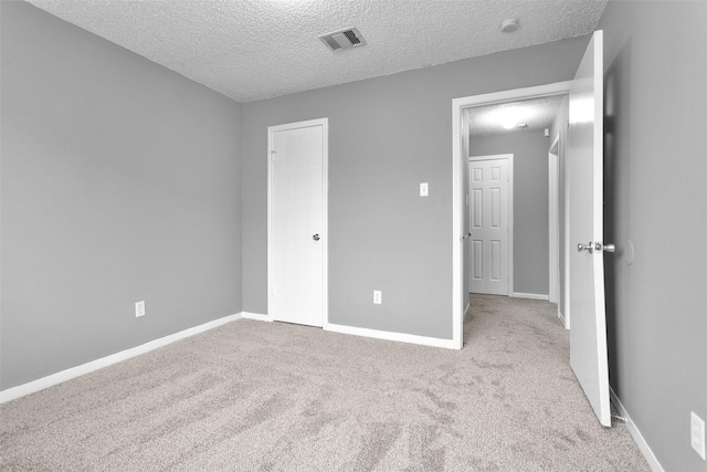 unfurnished bedroom with light colored carpet, visible vents, and baseboards