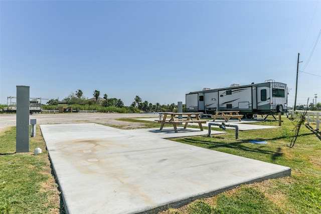 surrounding community featuring basketball hoop and a yard