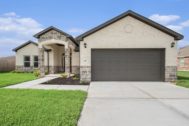 411 Wellshire Dr, West Columbia, TX 77486 - french country style house with concrete driveway, brick siding, a garage, and stone siding