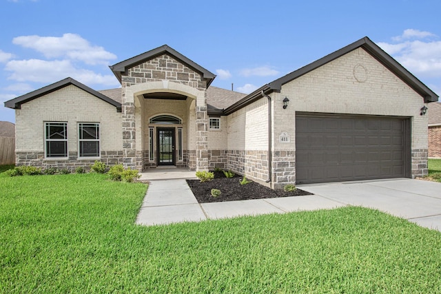 411 Wellshire Dr, West Columbia, TX 77486 - french country style house with stone siding, a garage, a front lawn, and concrete driveway