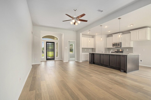 411 Wellshire Dr, West Columbia, TX 77486 - kitchen with appliances with stainless steel finishes, ceiling fan, light wood-style flooring, light countertops, and white cabinets