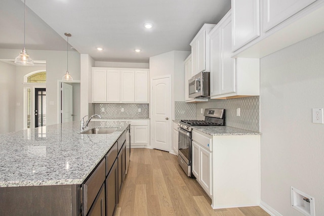 411 Wellshire Dr, West Columbia, TX 77486 - kitchen with appliances with stainless steel finishes, light wood finished floors, white cabinets, and recessed lighting