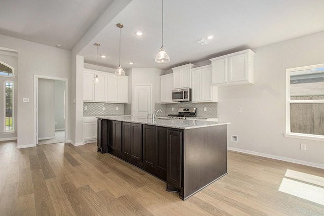 411 Wellshire Dr, West Columbia, TX 77486 - kitchen with appliances with stainless steel finishes, light wood-style floors, tasteful backsplash, white cabinets, and recessed lighting