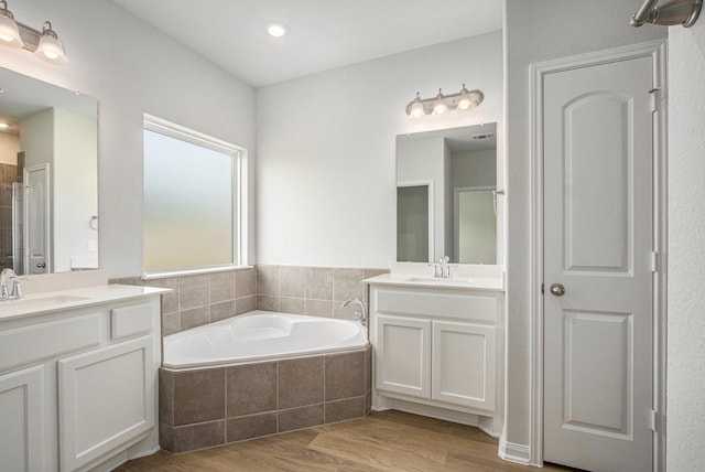 411 Wellshire Dr, West Columbia, TX 77486 - bathroom with two vanities, a bath, and wood finished floors