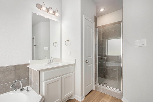 411 Wellshire Dr, West Columbia, TX 77486 - bathroom featuring a shower stall, vanity, wood finished floors, and a garden tub