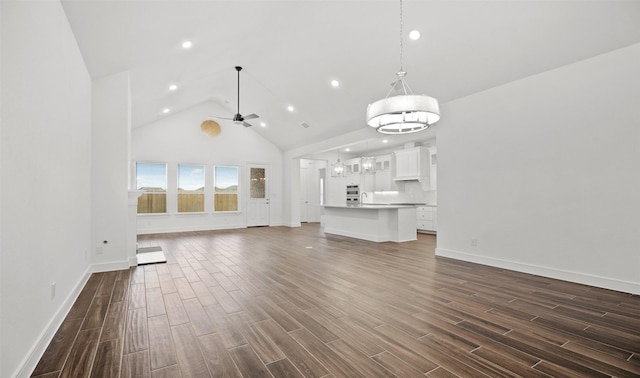 128 Luther Dean Ln, New Waverly, TX 77358 - unfurnished living room with high vaulted ceiling, dark wood-style floors, baseboards, recessed lighting, and a sink