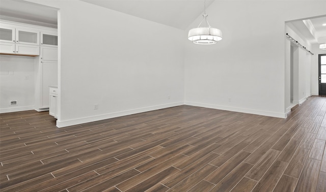 128 Luther Dean Ln, New Waverly, TX 77358 - unfurnished dining area featuring a barn door, dark wood-style flooring, baseboards, and lofted ceiling