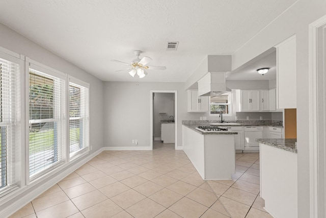 kitchen with ceiling fan, white dishwasher, stone counters, white cabinetry, and light tile patterned flooring