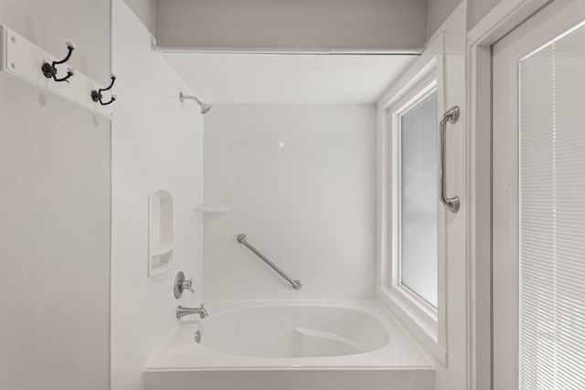 full bath with a textured ceiling and shower / bathtub combination