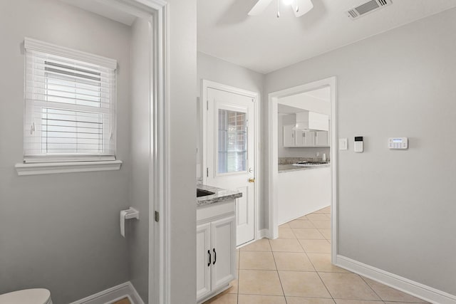 bathroom with baseboards, visible vents, a ceiling fan, tile patterned flooring, and vanity