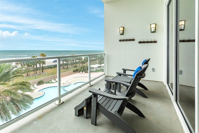 balcony featuring a beach view and a water view