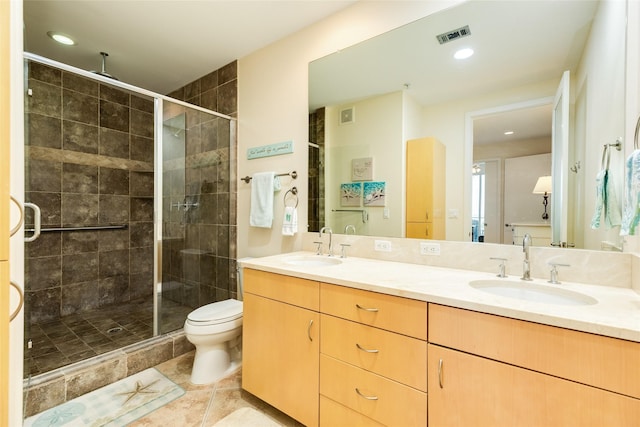 full bath featuring double vanity, a stall shower, toilet, and a sink