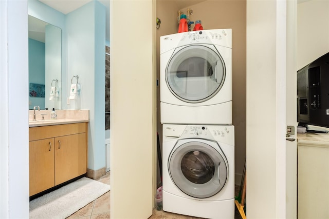 clothes washing area featuring stacked washer and clothes dryer, a sink, and light tile patterned floors