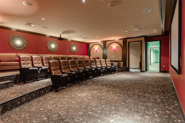 carpeted home theater with visible vents and crown molding