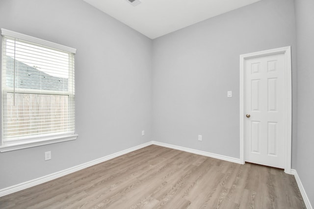 empty room with baseboards and light wood-style floors