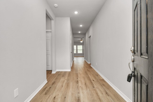 corridor featuring recessed lighting, light wood-style flooring, and baseboards