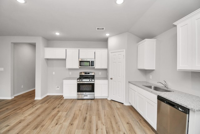 kitchen featuring stainless steel appliances, recessed lighting, white cabinets, and a sink