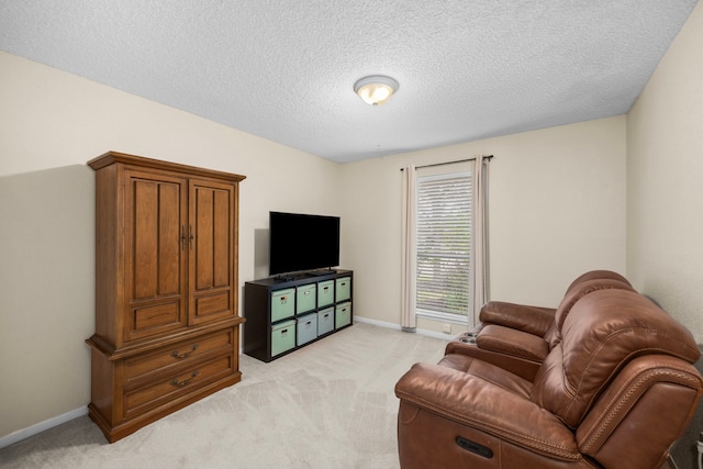 living area featuring baseboards, a textured ceiling, and light colored carpet