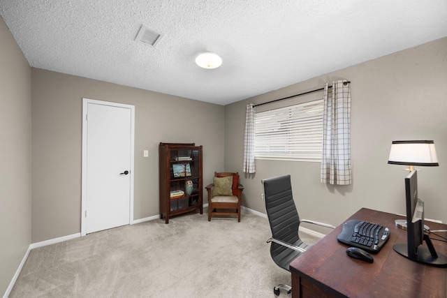 home office with baseboards, visible vents, a textured ceiling, and light colored carpet