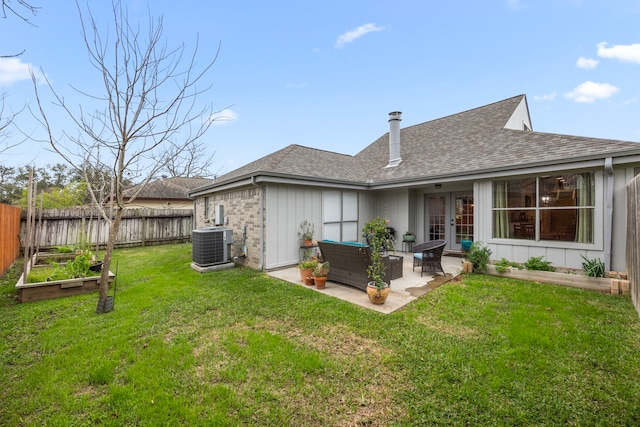 back of property featuring a vegetable garden, a patio, roof with shingles, outdoor lounge area, and central AC