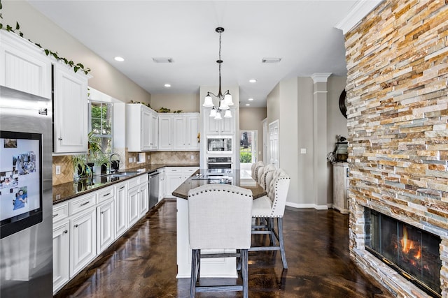 kitchen with visible vents, stainless steel appliances, white cabinetry, and pendant lighting