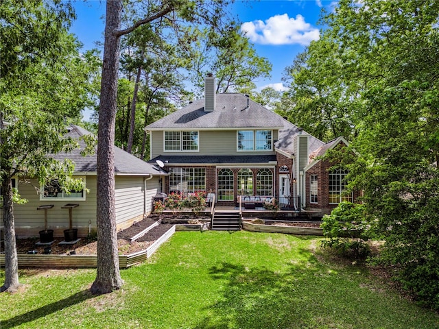 back of house with brick siding, a garden, a chimney, and a yard