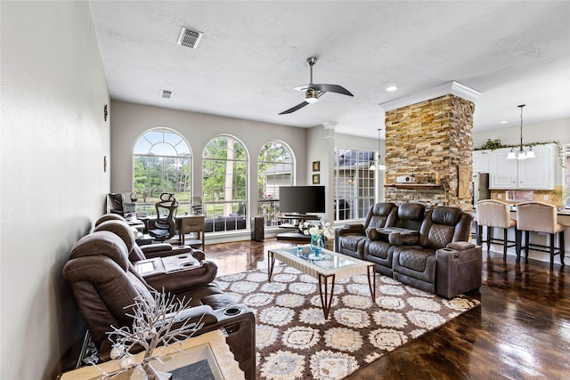 living area featuring a textured ceiling, wood finished floors, visible vents, and a ceiling fan