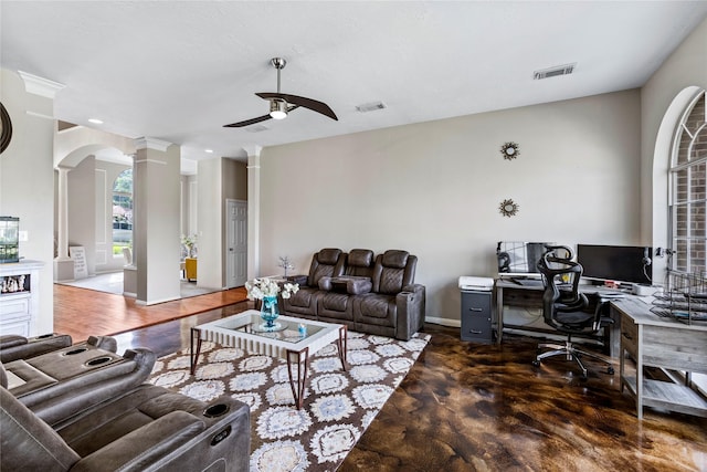 living room with finished concrete floors, visible vents, ornate columns, and a ceiling fan