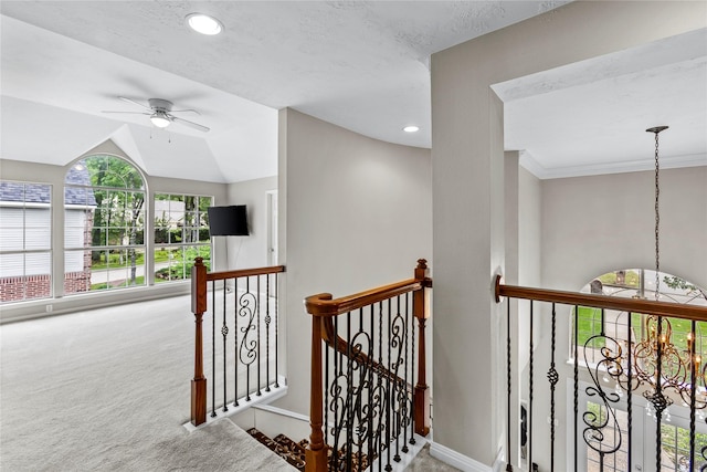 hall featuring carpet flooring, vaulted ceiling, a textured ceiling, an upstairs landing, and baseboards