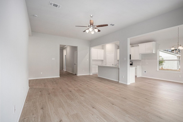 314 Wellshire Dr, West Columbia, TX 77486 - unfurnished living room featuring light wood-type flooring, ceiling fan, and a chandelier