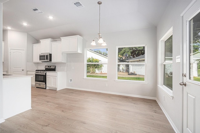 314 Wellshire Dr, West Columbia, TX 77486 - kitchen featuring stainless steel appliances, lofted ceiling, a chandelier, plenty of natural light, and white cabinetry