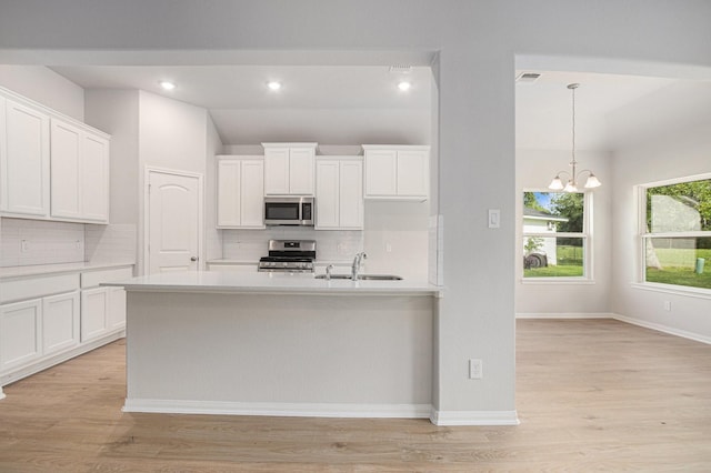 314 Wellshire Dr, West Columbia, TX 77486 - kitchen featuring stainless steel appliances, tasteful backsplash, a chandelier, light countertops, and white cabinetry