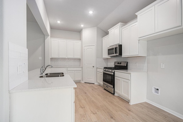 314 Wellshire Dr, West Columbia, TX 77486 - kitchen featuring stainless steel appliances, light wood-style floors, decorative backsplash, light stone countertops, and recessed lighting